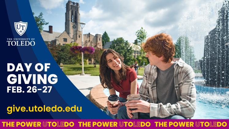 Two students sitting on the Student Union fountain, holding coffees, looking at each other and smiling