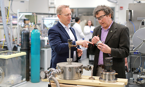 Interim President Matthew Schroeder inspecting a piece of equipment with Dr. Michael Heben